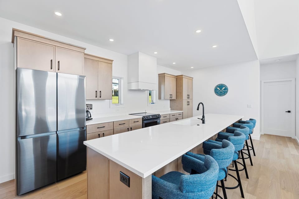 A bright, modern kitchen designed for effortless gathering. Featuring a spacious island, sleek appliances, and seating for the whole crew. 