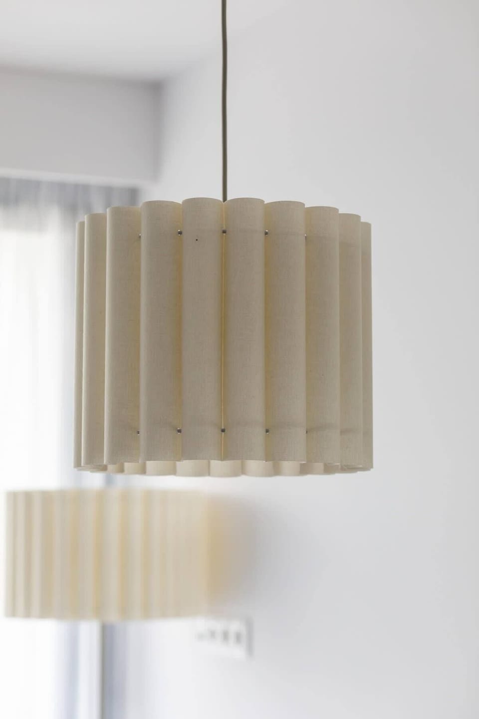 A close-up of a modern pendant lamp with a minimalist design. Adds a touch of elegance to the room’s interior.