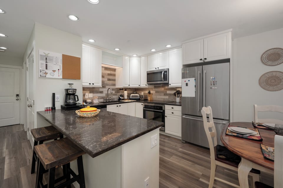 Whip up your favorite meals in this modern kitchen featuring granite counters, stainless appliances, and island seating.