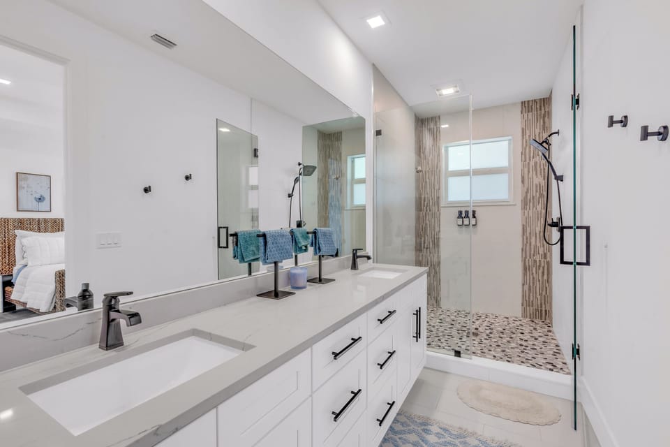 Spa-inspired primary bath with dual vanities and walk-in shower