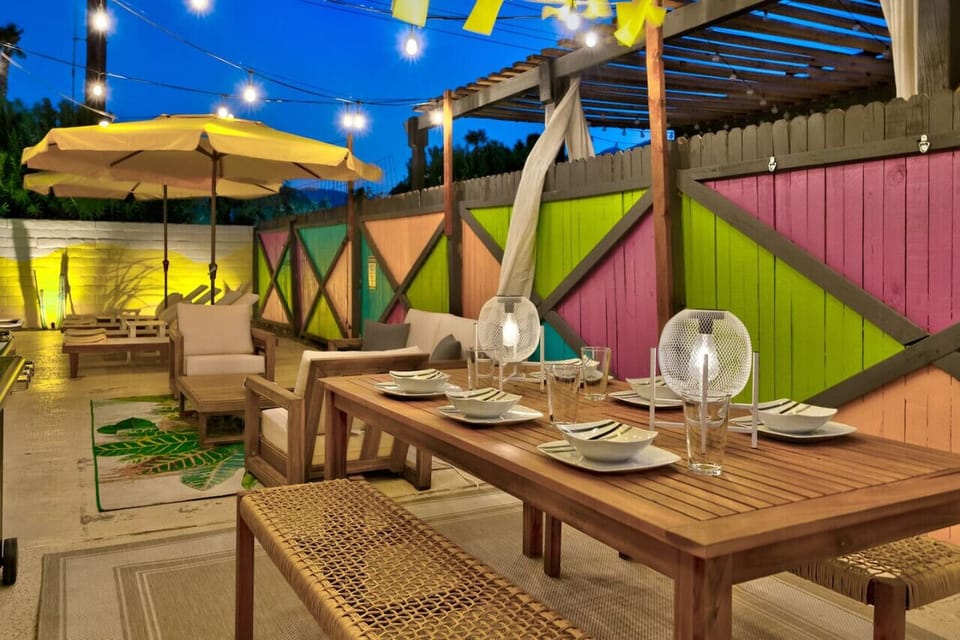 Dine al fresco in this charming outdoor space with colorful accents and cozy lighting