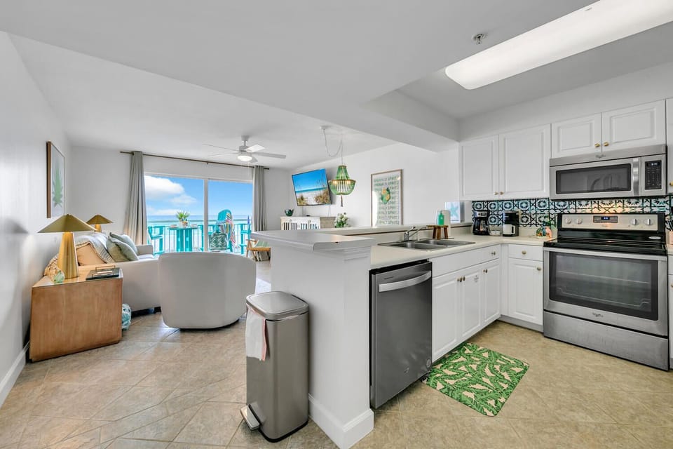 Your open-concept space flows from fully-equipped kitchen to living area, with stunning beach views framing your coastal getaway perfectly.