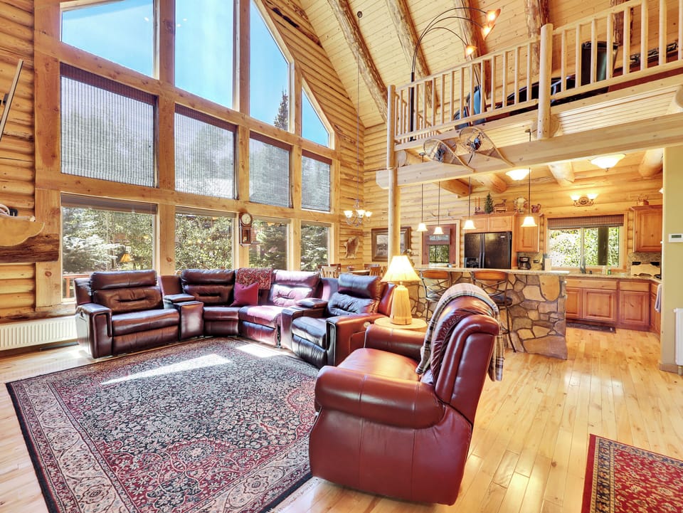 View of Living Room with ample seating and reclining chairs, gourmet kitchen and loft