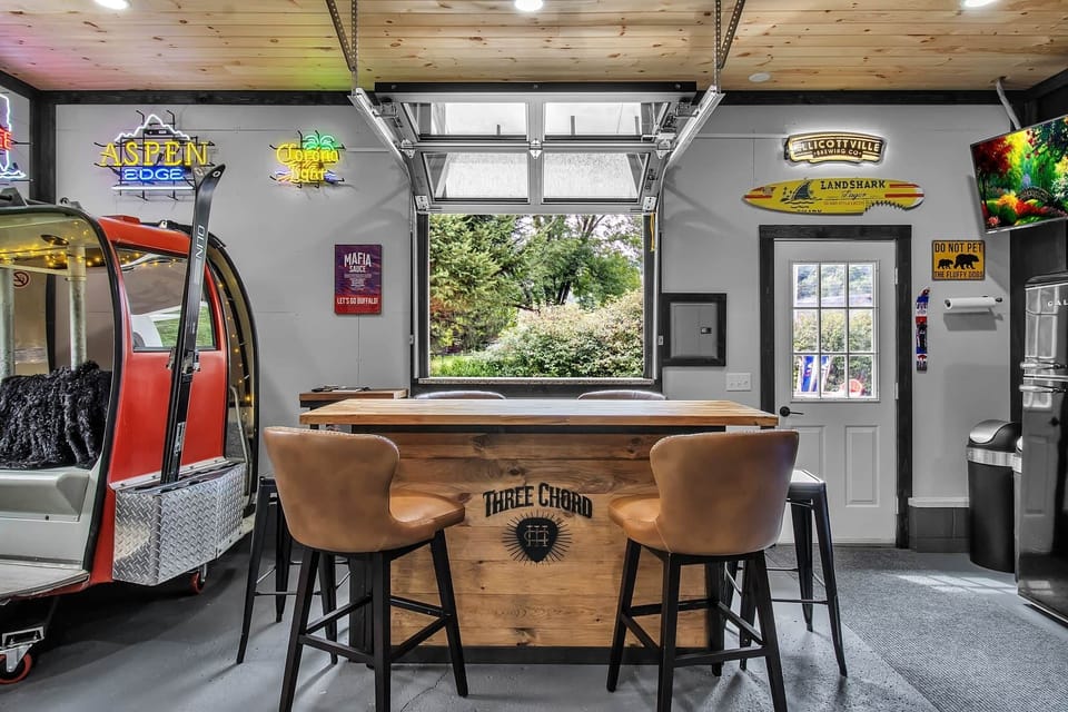 Indoor/outdoor bar window connects the game room to the patio and hot tub with mountain views.