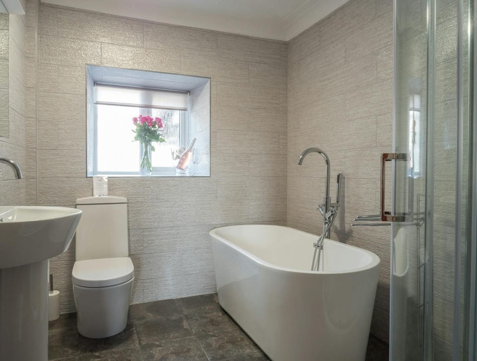 Free standing bath, corner shower unit, wash hand basin and WC