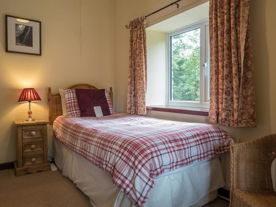 Single, bedside drawers with lamp and wicker chair