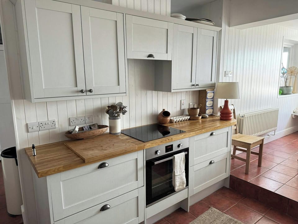 Fitted kitchen with built-in electric oven and hob, wall and base units