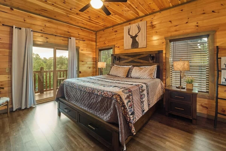 Unwind in this cozy king-size bedroom with a dresser, TV, closet, and private full bathroom. Step onto the balcony with seating to enjoy peaceful nature views. Designed for comfort and relaxation, this rustic retreat is perfect for a restful stay!