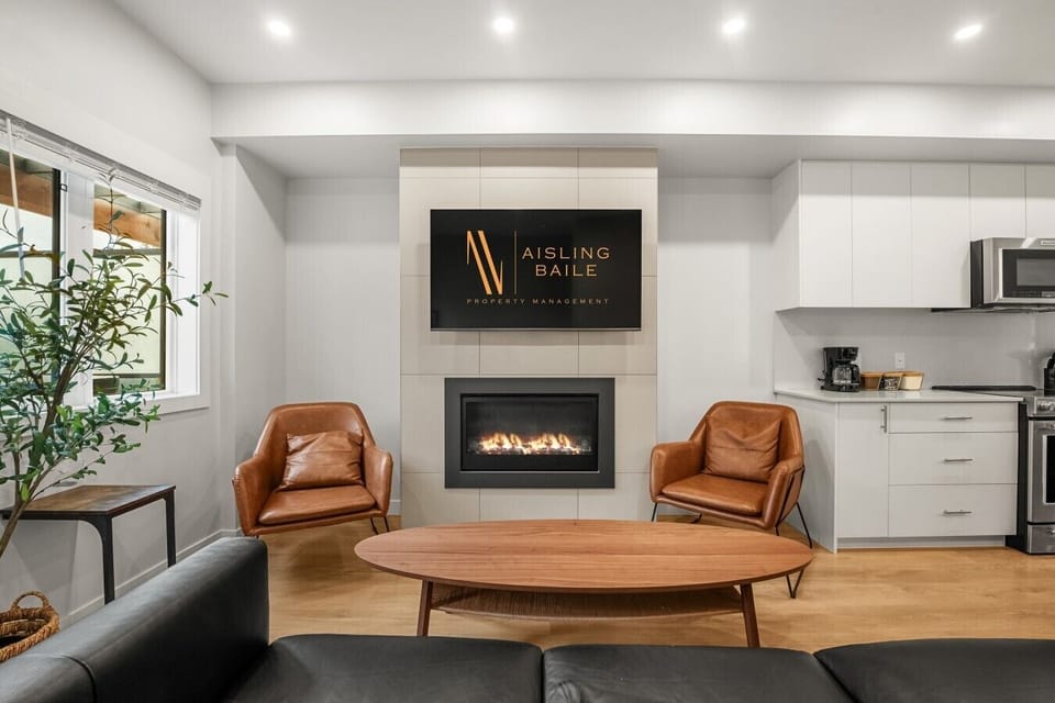 Living room on the main floor with a gas fireplace, Smart TV, cozy seating and walkout access to the balcony/hot tub.