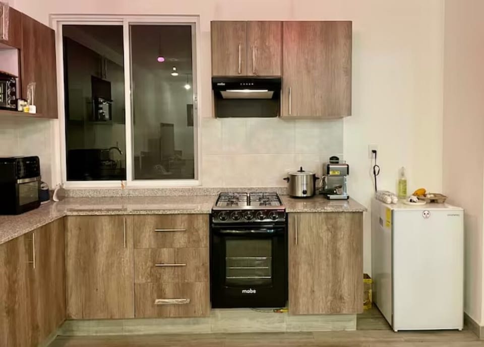 Cocina con refrigerador, horno, licuadora, cafetera y olla de lento cocimiento 