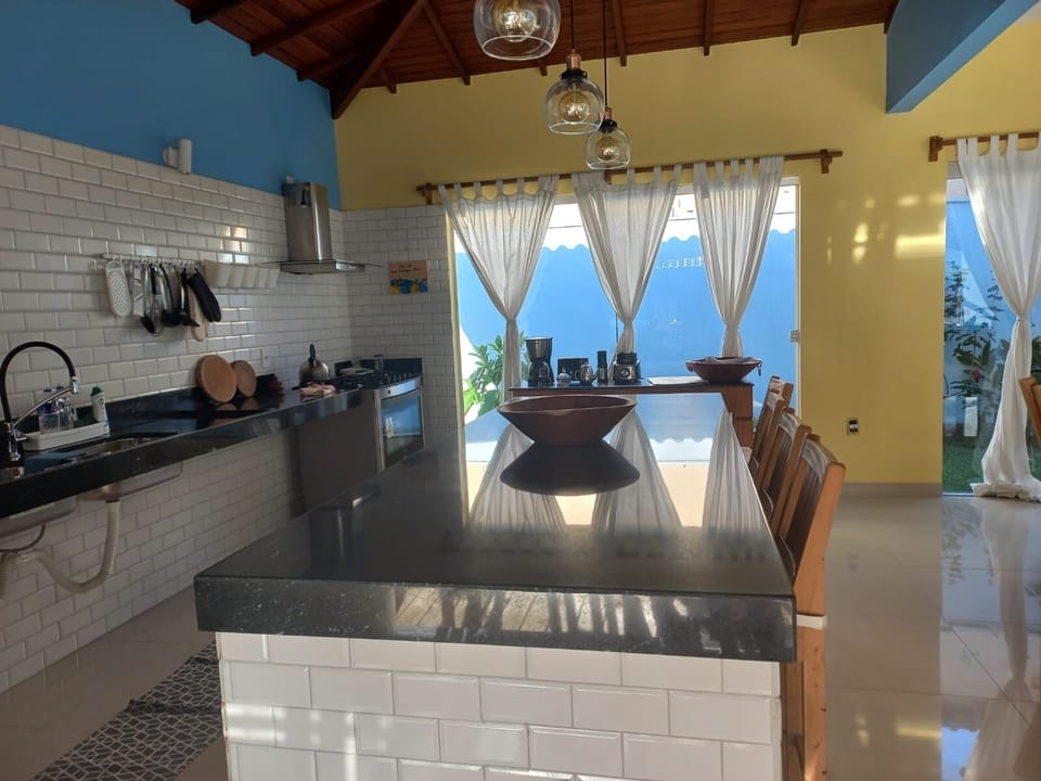 Cozinha com  fogão e ilha  perfeita pra café da manhã