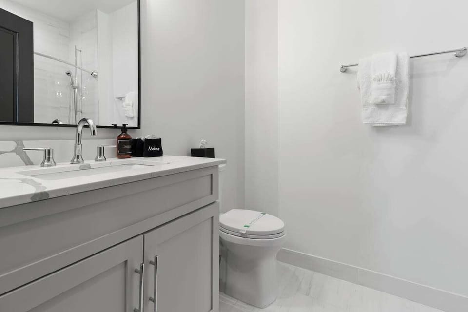 The guest bathroom includes fresh towels, a hairdryer, and complimentary toiletries. Conveniently located near the living area, it’s stylish and practical—perfect for guests, families, or sharing during group stays at 888 Baronne.