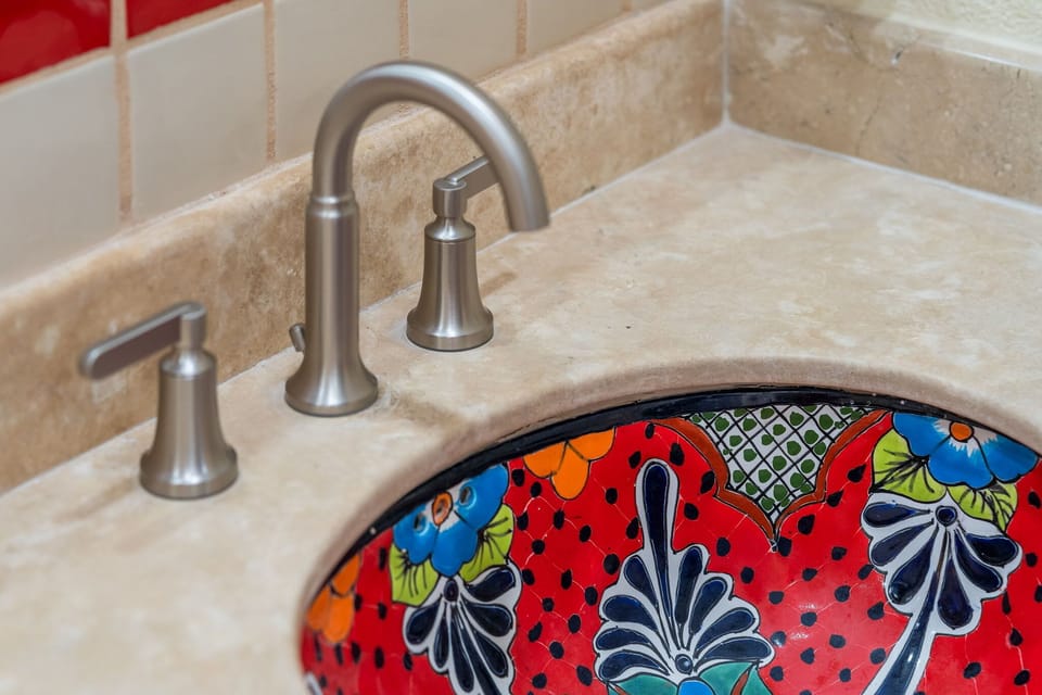Hand-painted sink basins and vibrant accents give this space authentic Mexican charm.