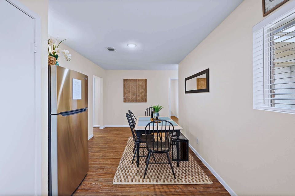 Dining Area: Gather around the sleek table for meals or games in this bright, inviting space.
