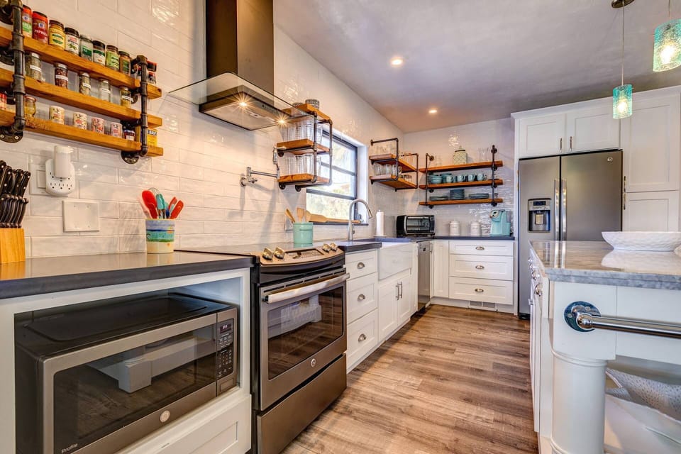 This kitchen is equipped with a microwave, oven, and fridge, providing all the essential appliances for convenient cooking and meal preparation.