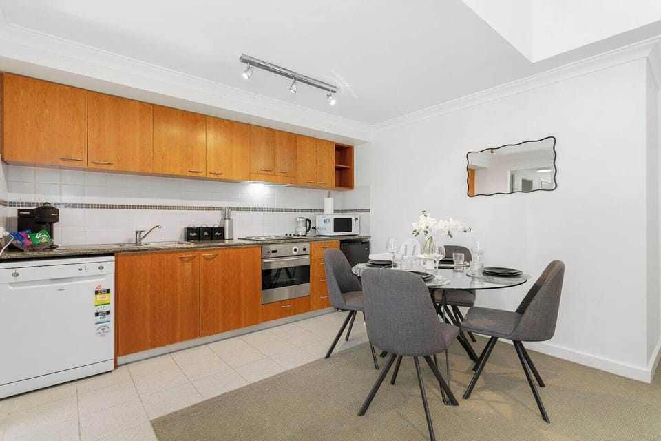 Modern kitchen with full amenities, including dishwasher and microwave, flowing seamlessly into a cozy dining area.