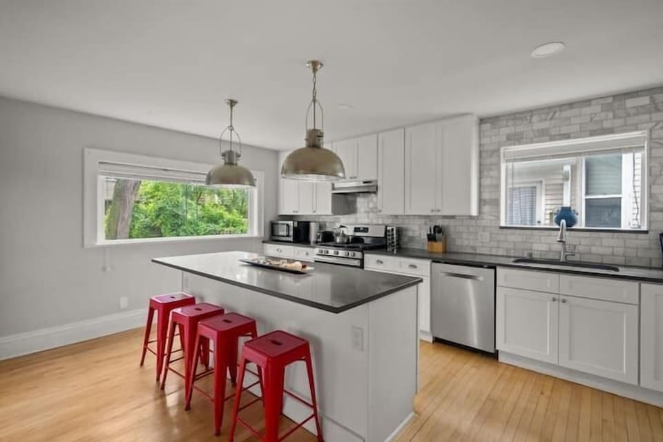Modern, fully equipped kitchen with a spacious island and seating for four