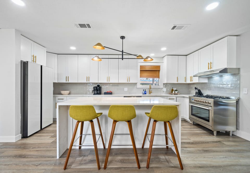 The bright and modern kitchen is fully equipped and ready for your culinary creations. Gather around the island for snacks or casual dining.