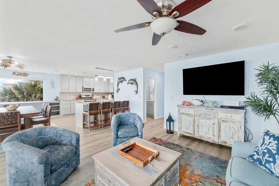 Your open-concept living space combines comfort and style with coastal blues, modern kitchen, and tropical touches for perfect relaxation.