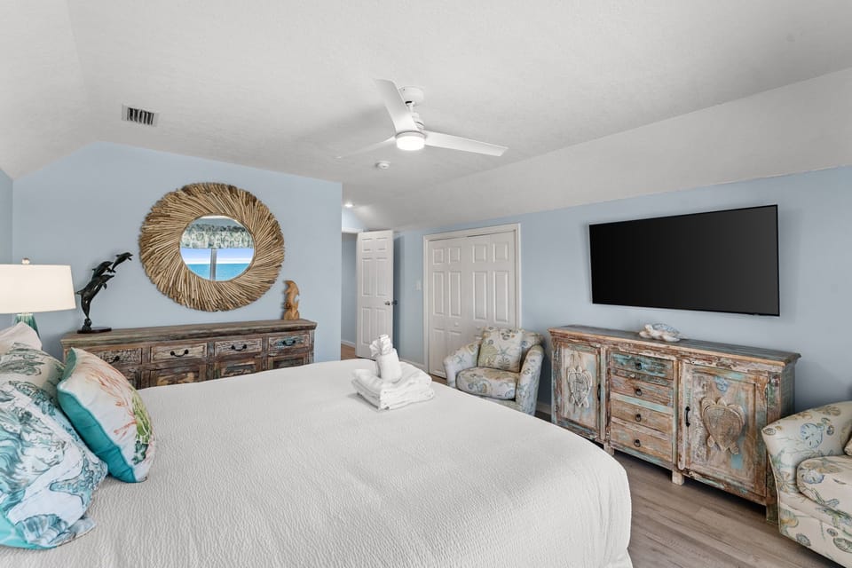 Drift off in your serene coastal bedroom, where soft blues and weathered wood create pure tranquility. Your private TV awaits for cozy evenings.