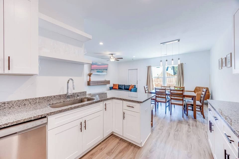 Modern and open, this brand-new kitchen with stainless steel appliances overlooks the dining and living areas, featuring big windows that fill the space with natural light.