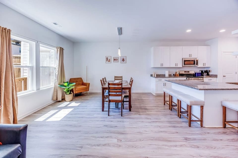 Enjoy meals at the dining table for six, perfectly situated between a wall with two large windows and the kitchen, creating a bright and welcoming space.