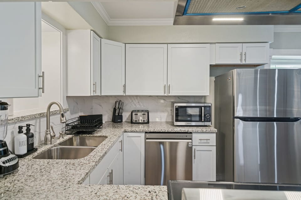 Modern kitchen with microwave, dishwasher, refrigerator/freezer, blender and toaster. Everything needed to cook a meal at home!