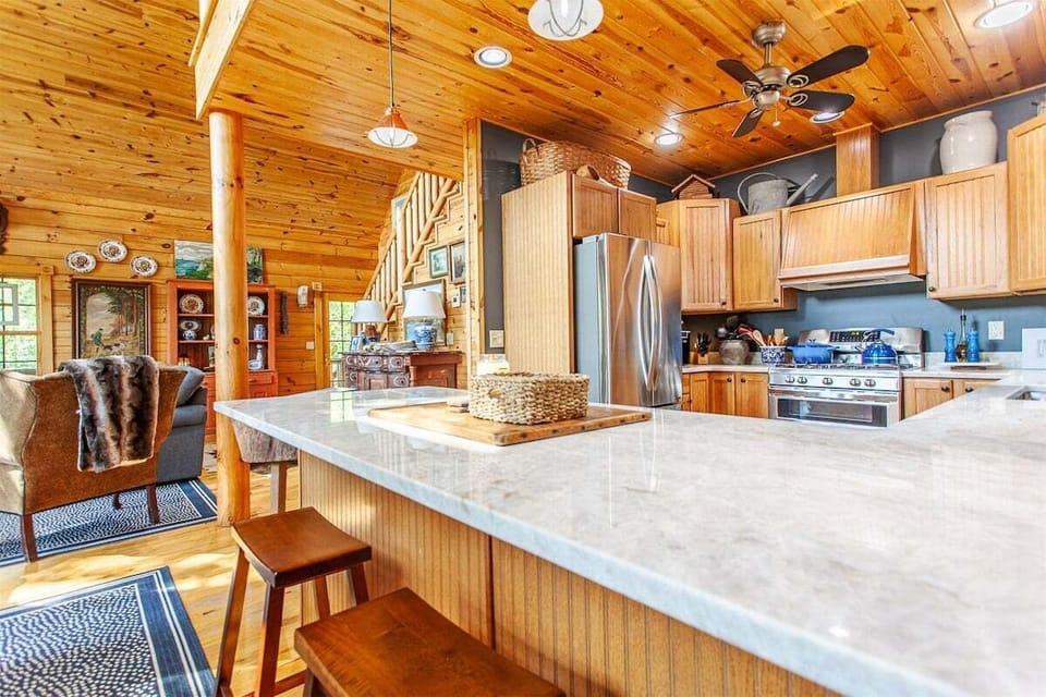 Full kitchen inside Hazy View Cabin featuring a generous bar seating, stainless steel appliances, and wood finishes perfect for entertaining.