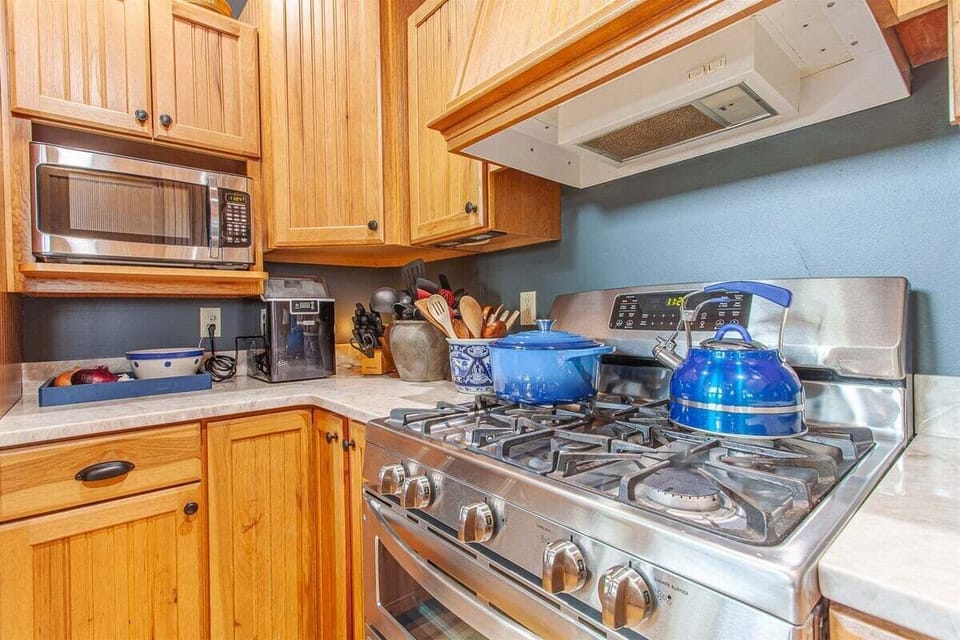 Open  kitchen with a gas stove, double-stack oven, and microwave, great for a group or family.