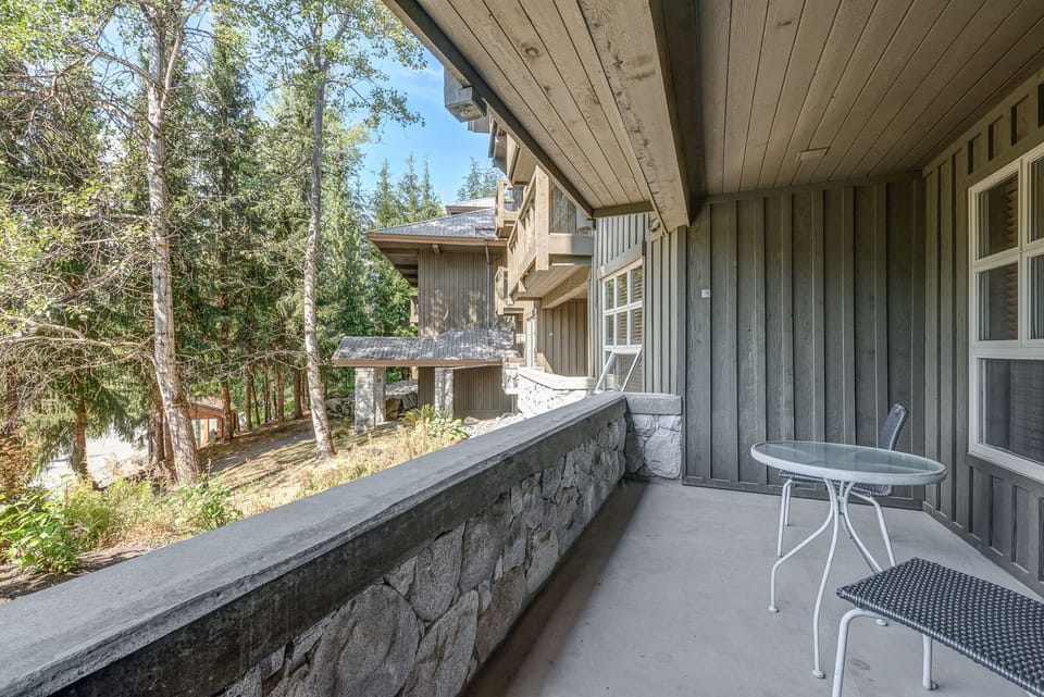 Private balcony with seating and peaceful views of the surrounding trees.