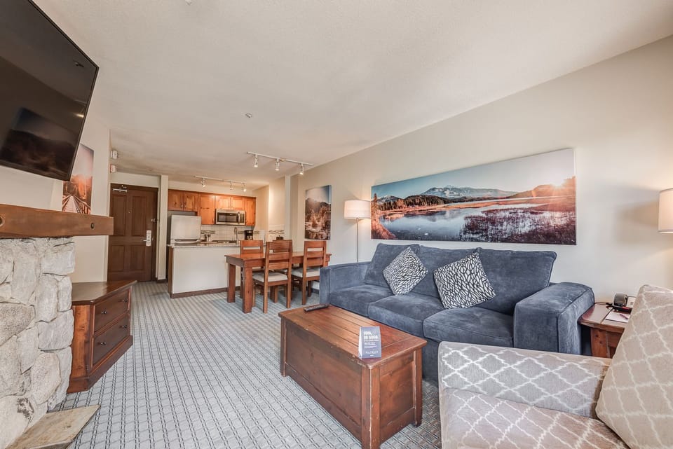 Spacious living area with a stone fireplace and cozy seating.