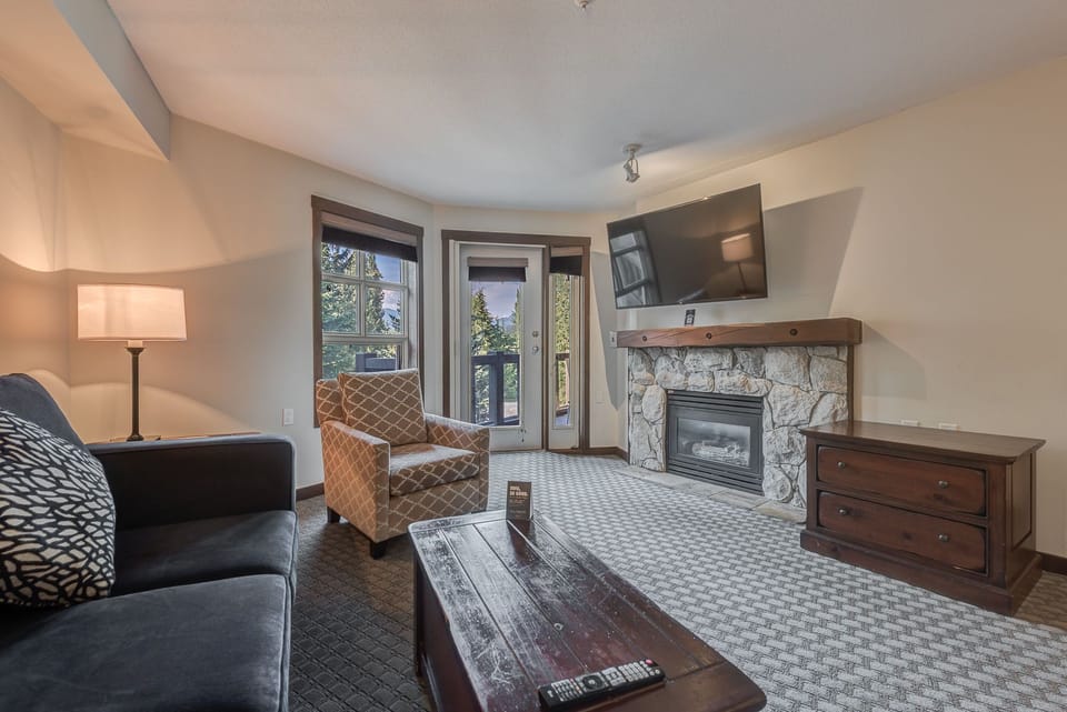 Relaxing living space with a stone fireplace and natural light.