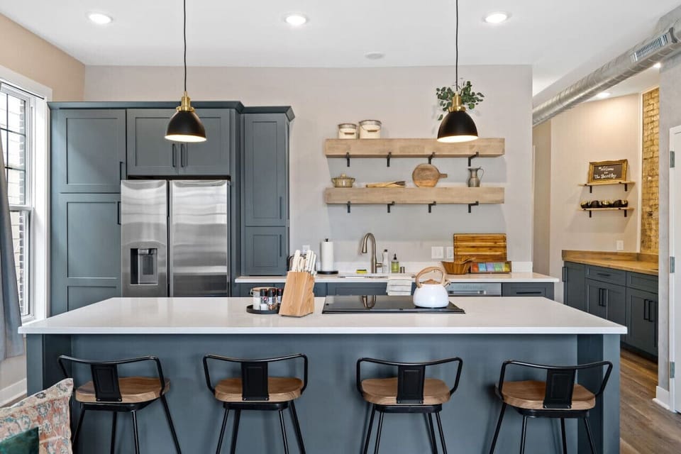 Fully equipped kitchen with stainless steel appliances, perfect for preparing meals or enjoying a coffee break.