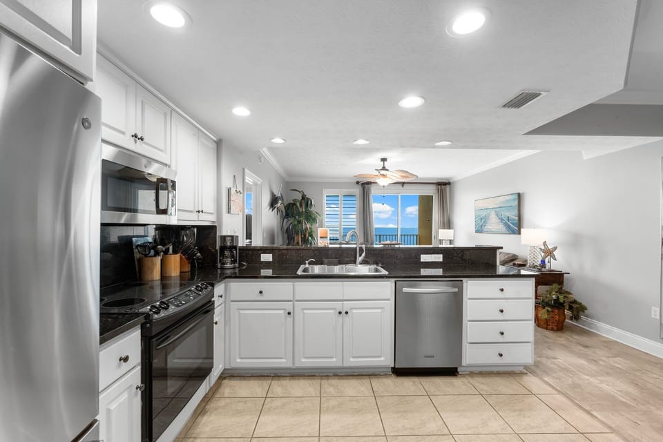 Modern kitchen with stainless steel appliances and a view into the living area.