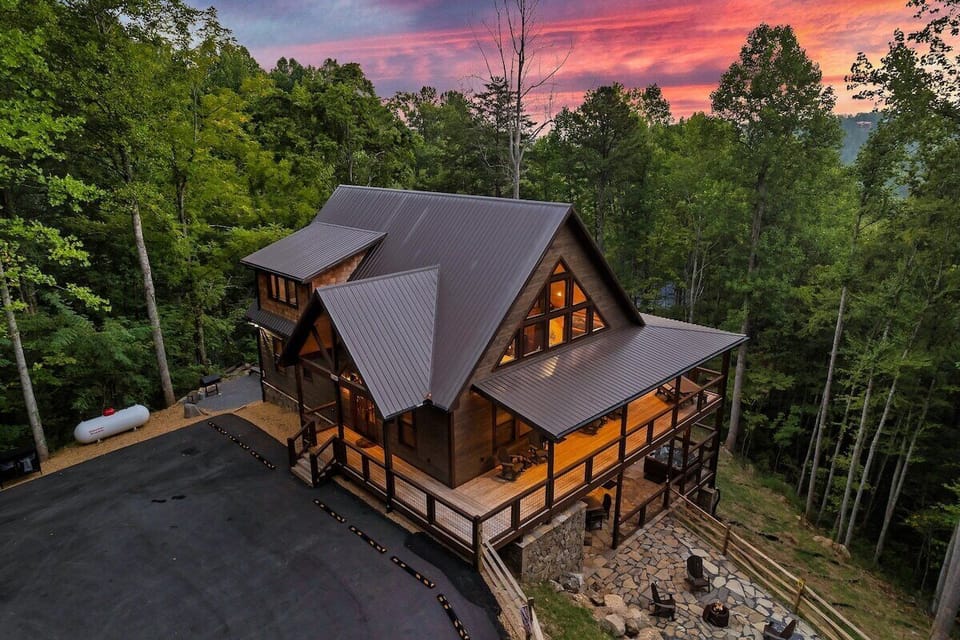 See the full picture from above, three stories, wraparound decks, stone fire pit, and forest on every side. This is the cabin your group will still be talking about next year.