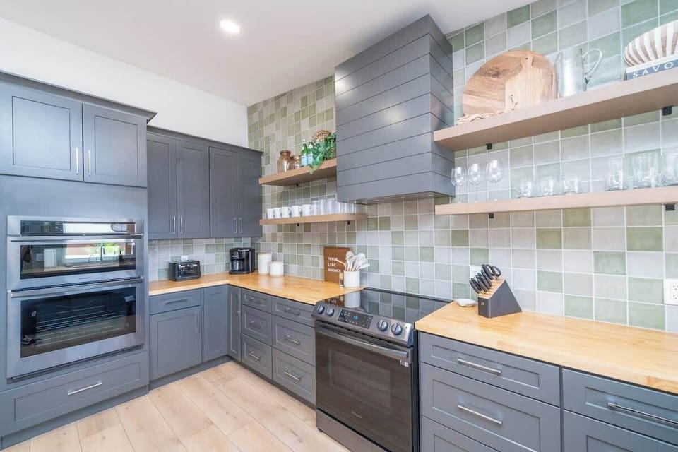 Upgraded black stainless steel appliances with doubles ovens for large family dinners. 