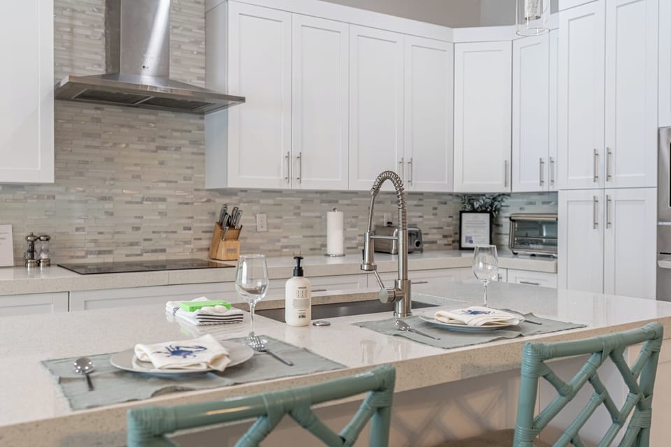 Get ready to whip up delicious meals in this fully-stocked chef’s kitchen! It features bar seating and brand new appliances—perfect for sharing great food and fun times! | Seaside Sanctuary, Naples, Florida | Voyax Luxury Vacation Rentals