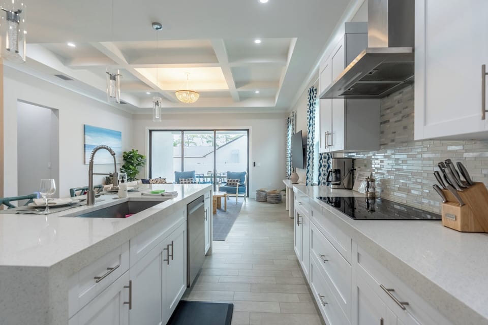 Get ready to whip up delicious meals in this fully-stocked chef’s kitchen! It features bar seating and brand new appliances—perfect for sharing great food and fun times! | Seaside Sanctuary, Naples, Florida | Voyax Luxury Vacation Rentals