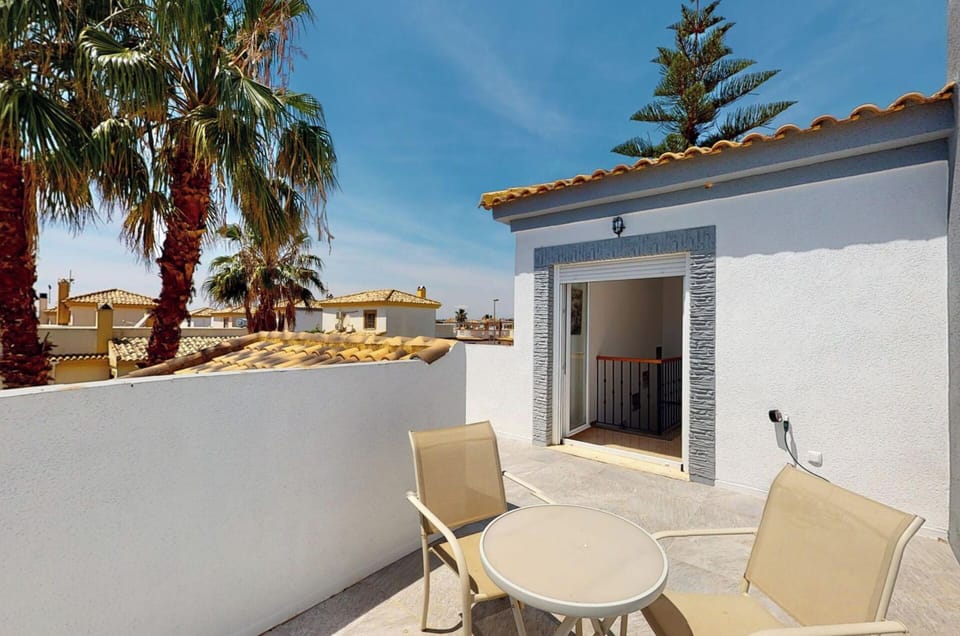 Balcony with table, chairs and sun beds