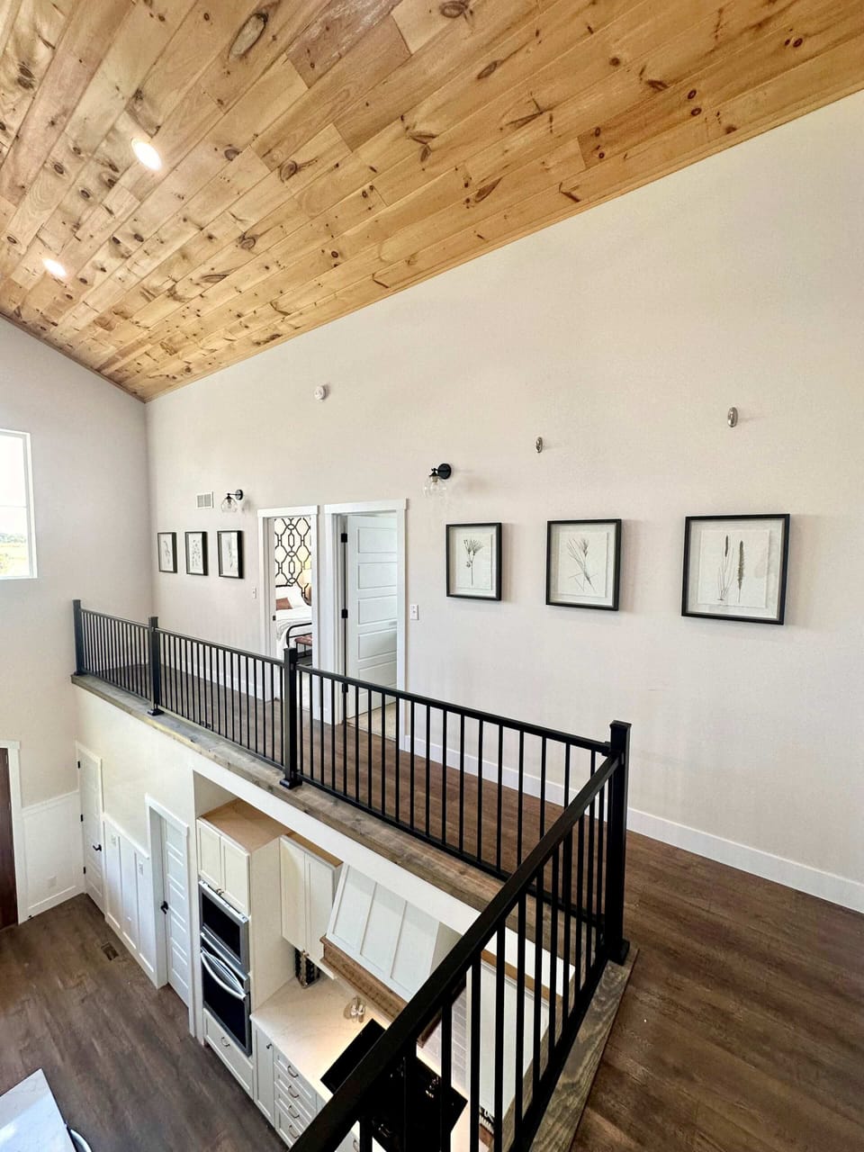 Stand up here and see the whole main floor at once. The wood ceiling runs all the way to the peak — the first thing guests notice when they walk in.