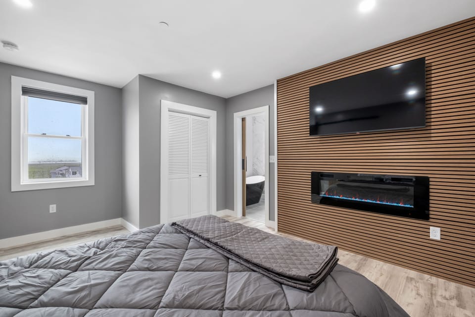 3rd floor primary bedroom w/ smart TV & electric fireplace plus an en suite bathroom