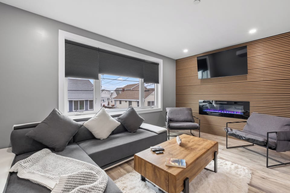 Living room with large comfy couch, smart TV, and electric fireplace perfect for a movie night! *This couch also doubles as an additional sleeping option.