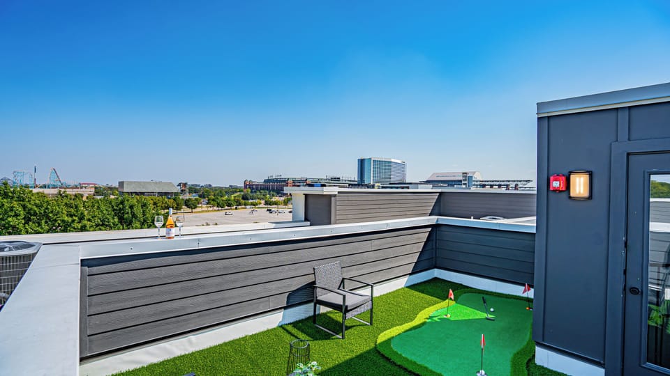 Experience the ultimate relaxation on a spacious rooftop deck with cozy lounge chairs and stunning views, perfect for sipping a drink as the sun sets over Arlington's entertainment district.