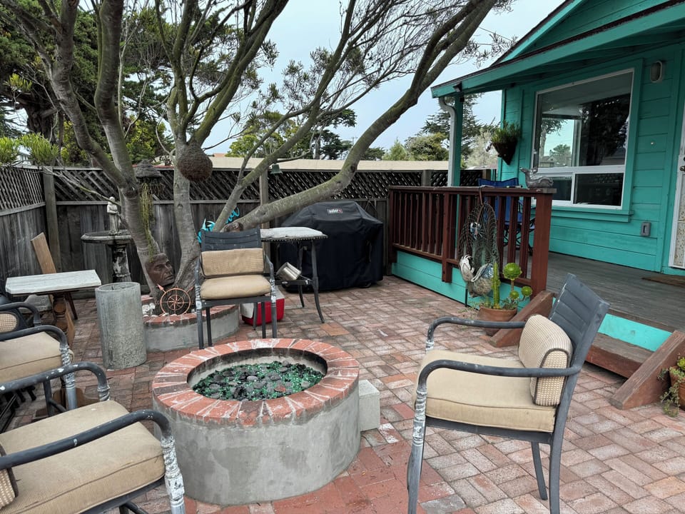 Outdoor patio with fire pit, grill, and stand up paddleboards to take on the bay