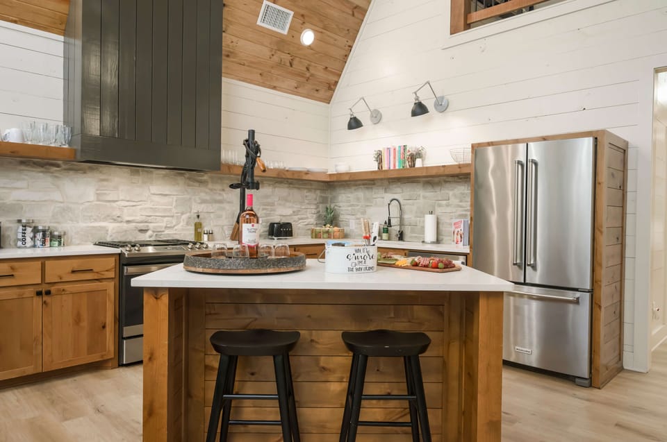 Warm kitchen featuring wood, stainless steel, and stone accents.