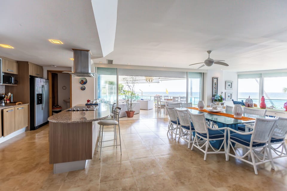 Spacious living room with a full kitchen, dining table for 8, central A/C, and an amazing beach view.