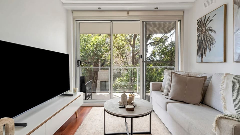 The perfect inner-city retreat. This beautifully styled living and dining space boasts a sleek glass-top table, elegant textured artwork, and a peaceful atmosphere that makes coming home a dream.