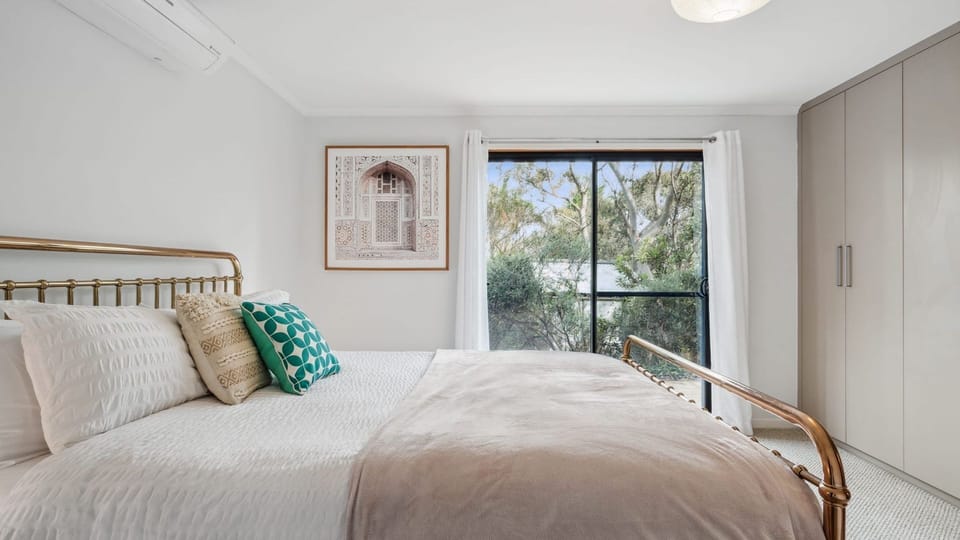 Bright bedroom with large windows bringing in plenty of natural light.