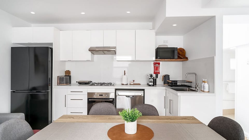 Functional kitchen with stovetop, oven, and modern appliances.