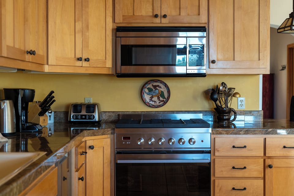 Detail of kitchen with custom solid wood cabinetry and granite counters.